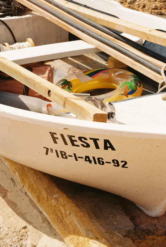 Fotografía analógica Fiesta en Ibiza por Sofía Gómez-Fonzo, barco en la playa con salvavidas