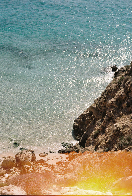 Fotografía analógica Life’s a Beach en Ibiza por Sofía Gómez-Fonzo, luz dorada en cala de la costa oeste