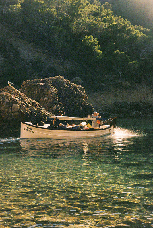 Fotografía analógica Domingo III en Ibiza por Sofía Gómez-Fonzo, barco saliendo de cala de pesca en el norte