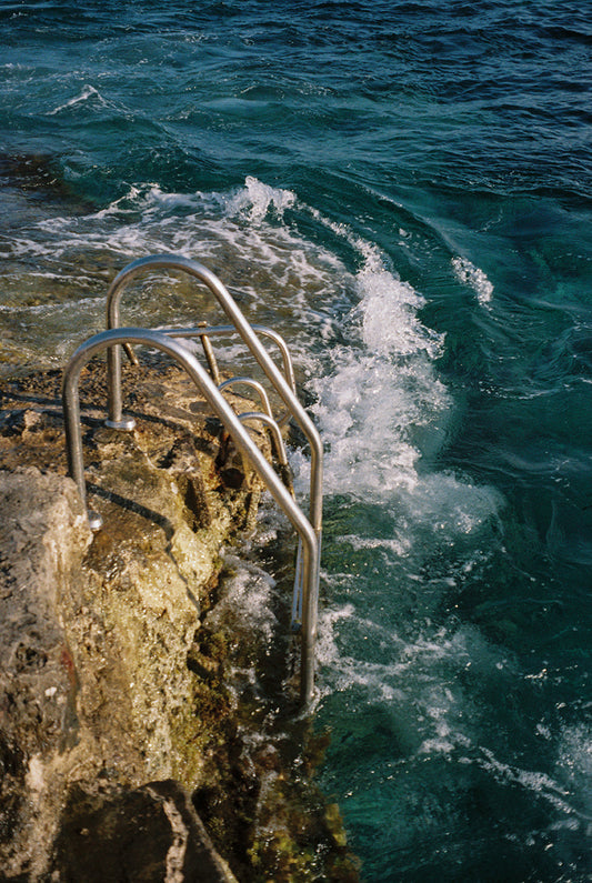 Fotografía analógica en Ibiza por Sofía Gómez-Fonzo, rocas escarpadas junto al mar